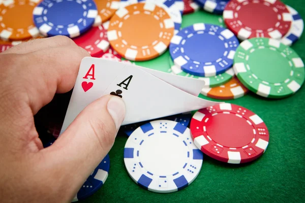 Player shows pocket aces on a casino table — Stock Photo, Image