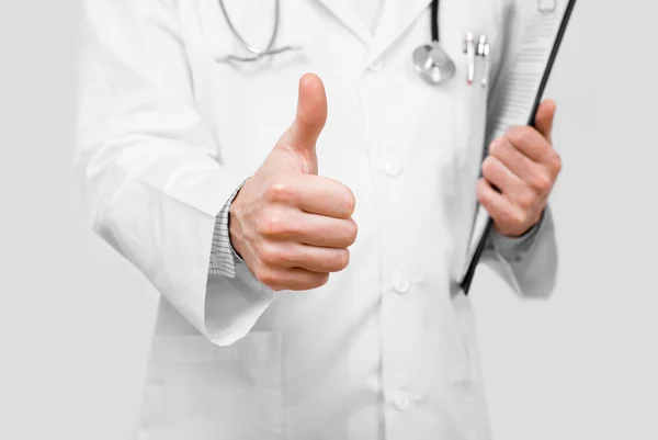 Молодой доктор показывает знак ОК с большим пальцем вверх изолированы на сером фоне — стоковое фото