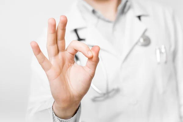 Médico joven con manos en forma de corazón aisladas sobre fondo blanco —  Fotos de Stock
