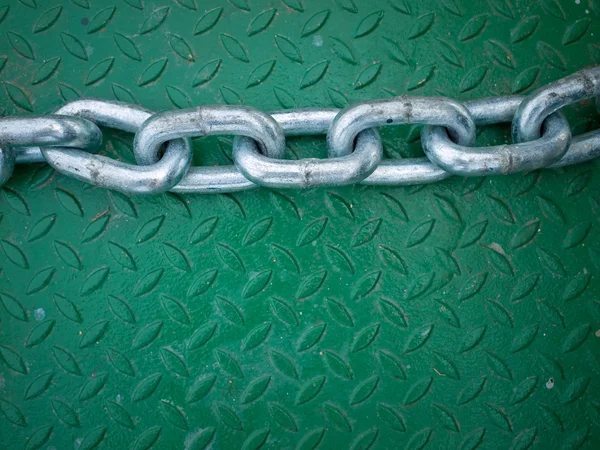 Ασημένια αλυσίδα στο πράσινο χάλυβα πλάκα — Φωτογραφία Αρχείου