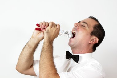 Guy with bow tie is trying to take out tooth with pliers