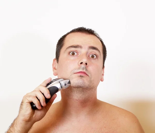 用电动剃须刀，剃掉了胡子的男人 — 图库照片