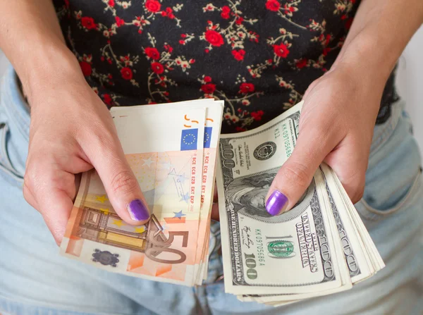 Woman's hands holding dollars and euros — Stock Photo, Image