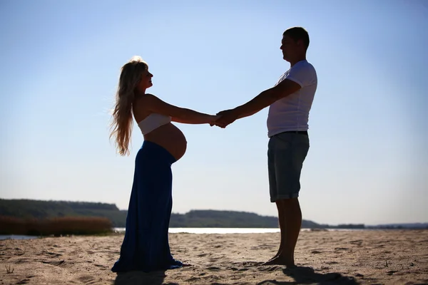Silhuett av gravid kvinna och man — Stockfoto