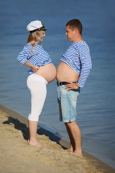 Wife and husband comparing bellies — Stock Photo, Image