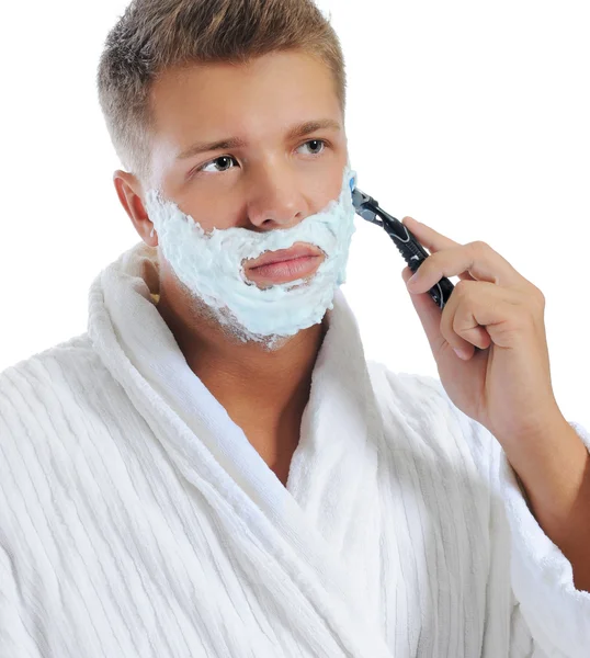 Junger Mann rasiert sich Stockfoto