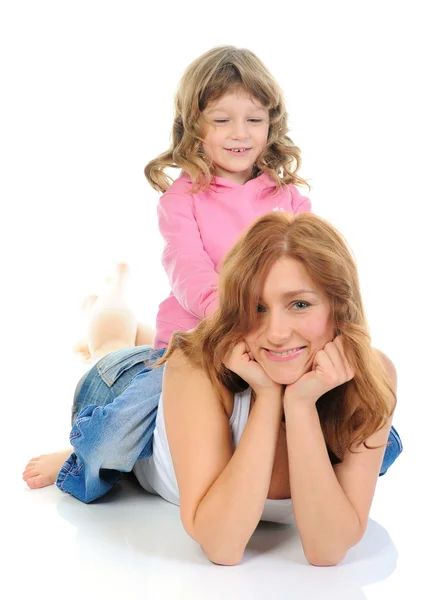 Fröhliches Mädchen umarmt ihre junge Mutter. — Stockfoto
