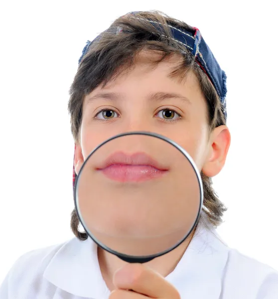 Boy looking through a magnifying glass — Stock Photo, Image