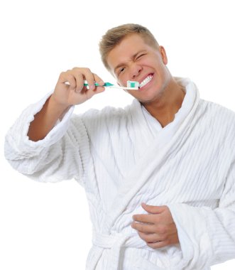 Adam dişlerini fırçalıyor.