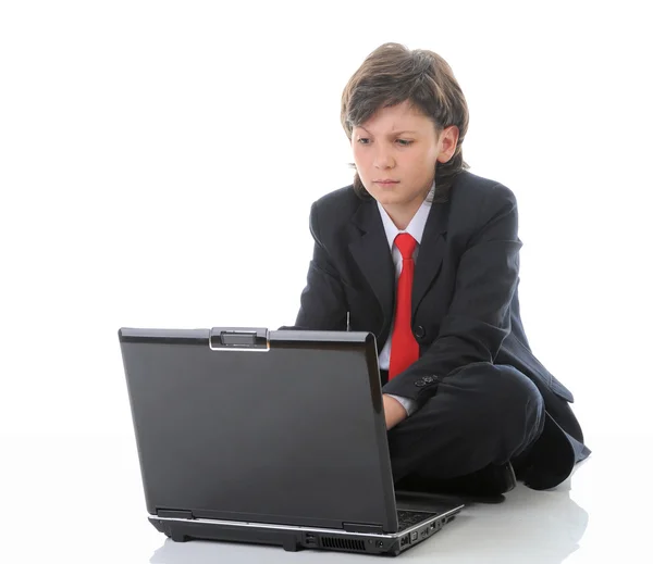 Αγόρι στο επαγγελματικό κοστούμι, κάθεται μπροστά από τον υπολογιστή — Φωτογραφία Αρχείου