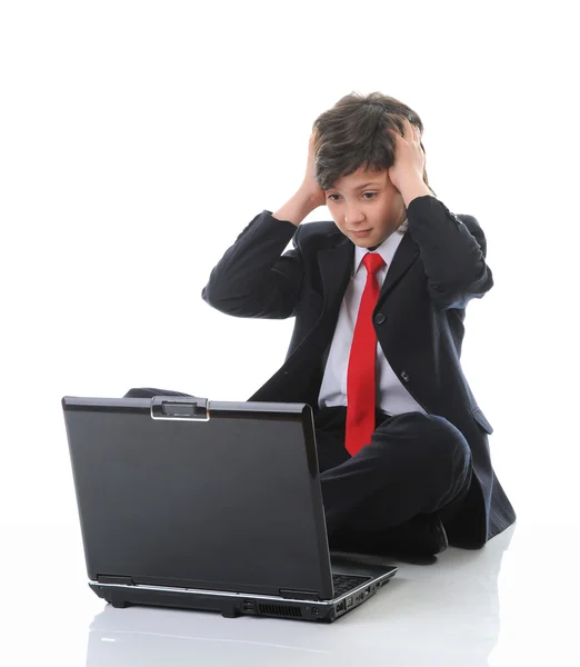 비지니스 정장을 입고 컴퓨터 앞에 앉아 있는 소년 — 스톡 사진