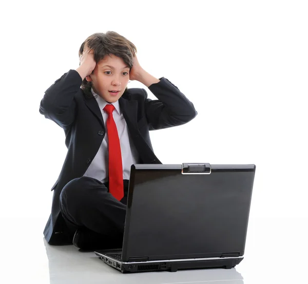 Junge im Businessanzug sitzt vor dem Computer lizenzfreie Stockbilder