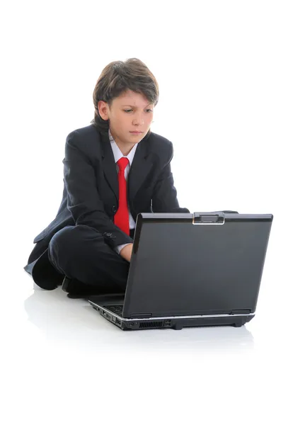Αγόρι στο επαγγελματικό κοστούμι, κάθεται μπροστά από τον υπολογιστή — Φωτογραφία Αρχείου