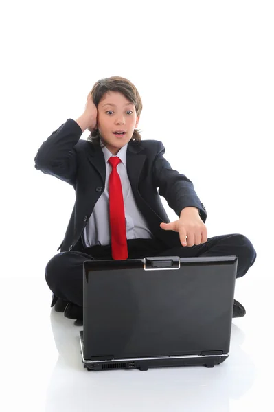 비지니스 정장을 입고 컴퓨터 앞에 앉아 있는 소년 — 스톡 사진