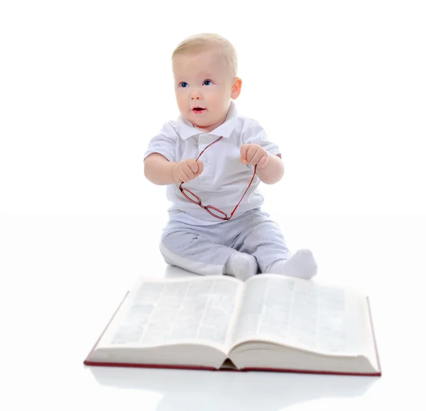 Liten pojke läser en stor bok — Stockfoto