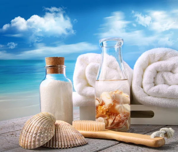 Handdukar med bad tillbehör på stranden — Stockfoto