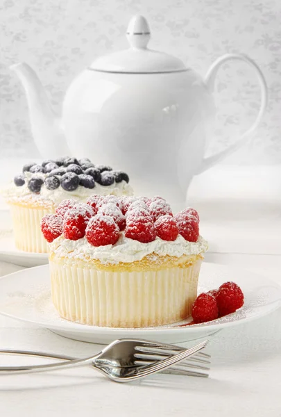 Cupcakes with raspberries and cream on table — Stock Photo, Image