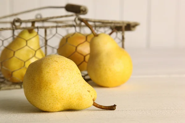 Färska mogna päron i korgen på bordet — Stockfoto