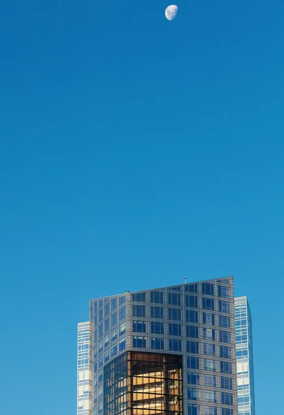 Belos edifícios de escritórios modernos e a lua contra o azul — Fotografia de Stock