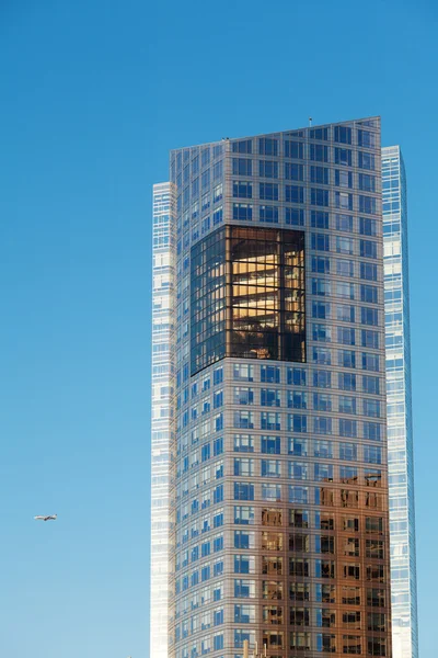 Schöne moderne Bürogebäude und Flugzeug gegen den blauen s — Stockfoto
