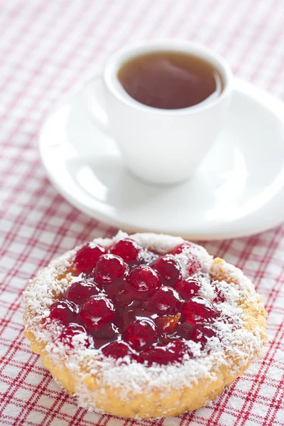 Prachtige cake met bessen en thee op geruite stof — Stockfoto