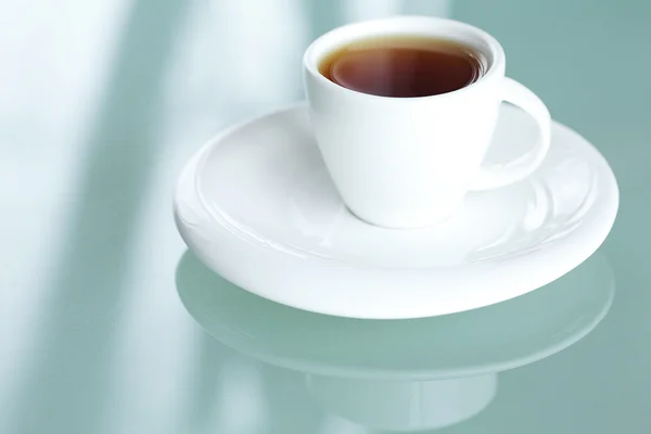 Чашка чая на стеклянной поверхности — стоковое фото