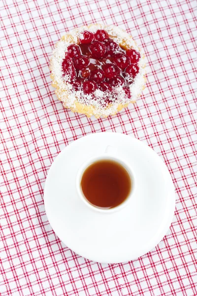 stock image Beautiful cake with berries and tea on plaid fabric