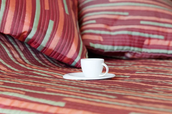 Lit avec deux oreillers, une tasse de thé sur la couverture — Photo