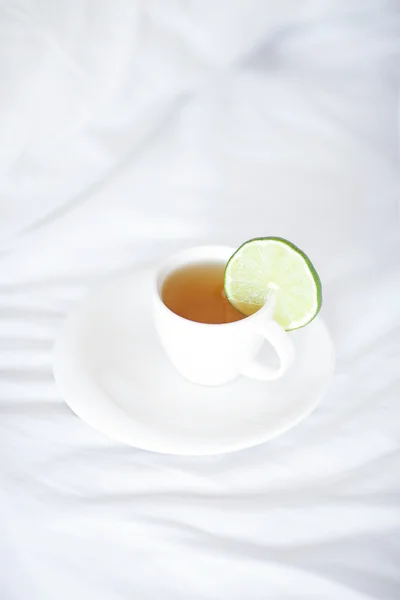 Łóżko z poduszką i filiżankę herbaty — Zdjęcie stockowe