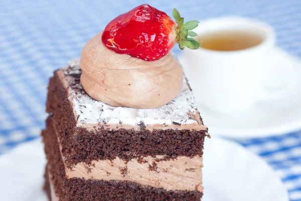 Beautiful cake with strawberry and tea on plaid fabric — Stock Photo, Image