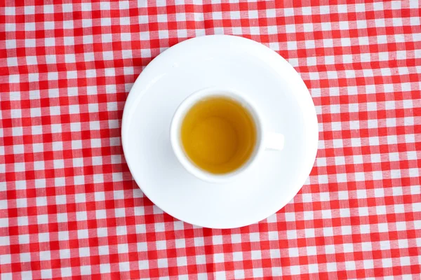 Cup of tea on plaid fabric — Stock Photo, Image
