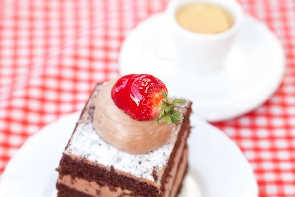 Belo bolo com morango e chá em tecido xadrez — Fotografia de Stock