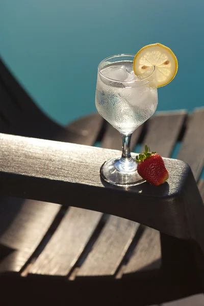 Piscina, salón, una copa de vino con hielo, limón y fresa —  Fotos de Stock