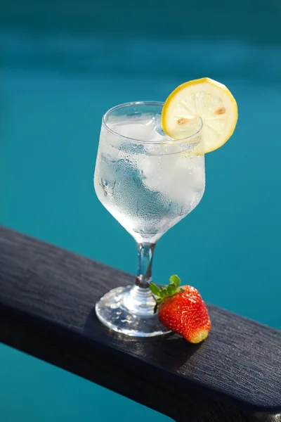 Swimming pool, lounge, a wine glass with ice, lemon and strawber — Stock Photo, Image