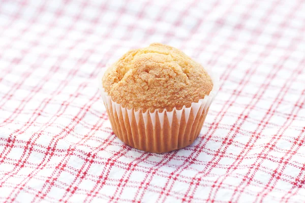 One muffin on plaid fabric — Stock Photo, Image