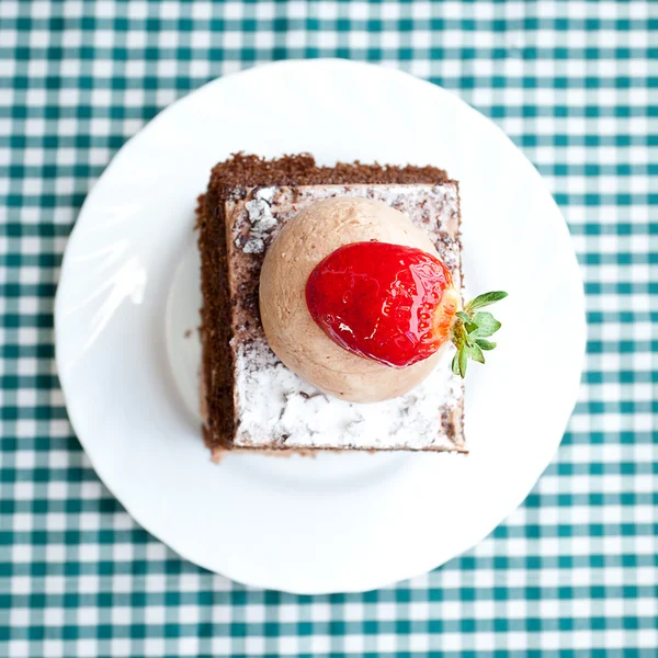 Красивый торт с клубникой на клетчатой ткани — стоковое фото