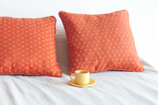 Łóżko z dwoma poduszkami, filiżankę herbaty na koc — Zdjęcie stockowe