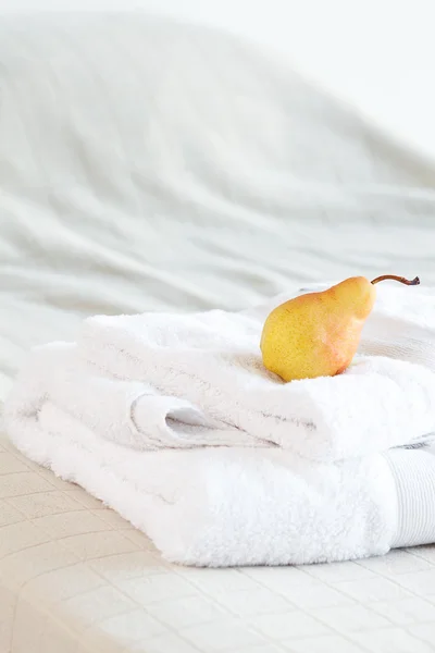 Pera acostada sobre toallas en la cama —  Fotos de Stock