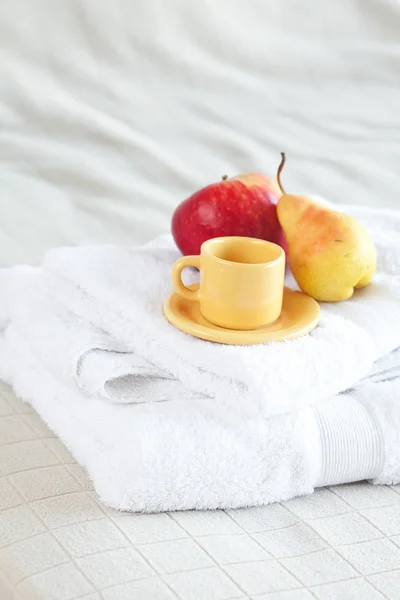 Copo, maçã e pêra em toalhas na cama — Fotografia de Stock