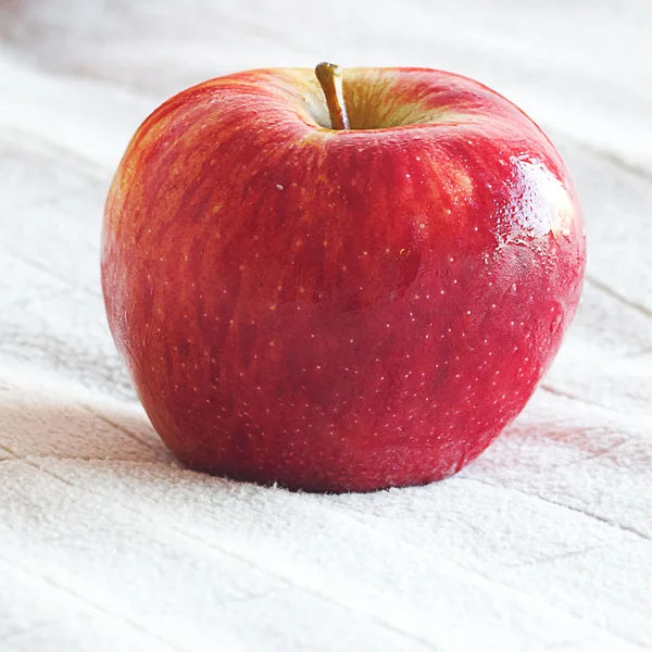 Apple lying on the blanket of bed — Stock Photo, Image
