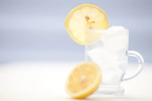 Acqua con limone e lime in un bicchiere con ghiaccio — Foto Stock
