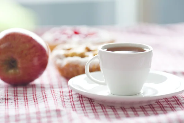 Schöner Kuchen mit Beeren, Apfel und Tee auf kariertem Stoff — Stockfoto