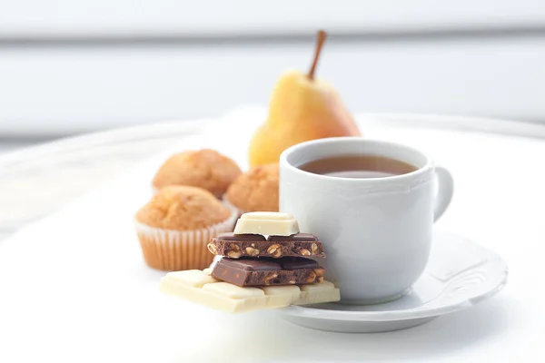 Bar of chocolate,tea, muffin and pear — Stock Photo, Image