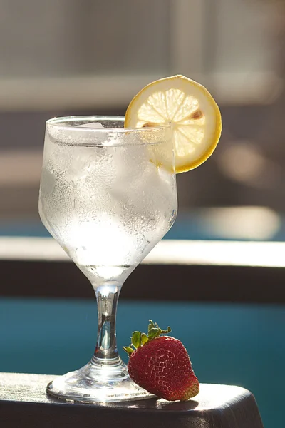 Piscina, salão, um copo de vinho com gelo, limão e palha — Fotografia de Stock