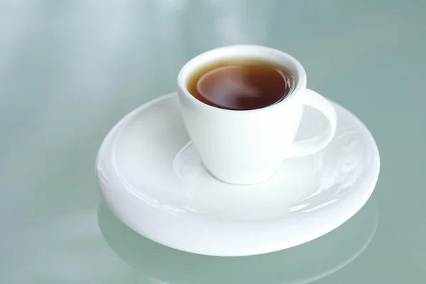 Taza de té en una superficie de vidrio —  Fotos de Stock