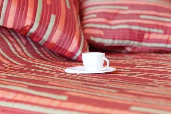 Bett mit zwei Kissen, eine Tasse Tee auf der Decke — Stockfoto
