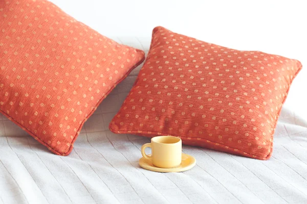 Ліжко з двома подушками, чашка чаю на ковдрі — стокове фото