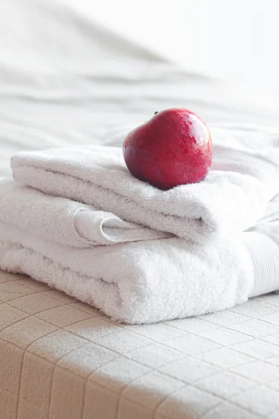 Μήλο που βρίσκεται στις πετσέτες στο κρεβάτι — Φωτογραφία Αρχείου