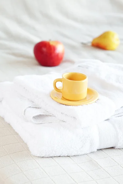 Чашка чая, яблоко и груша на кровати — стоковое фото
