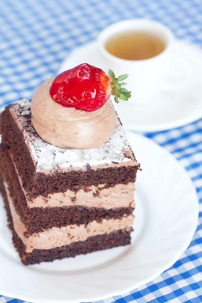Prachtige cake met aardbei en thee op geruite stof — Stockfoto